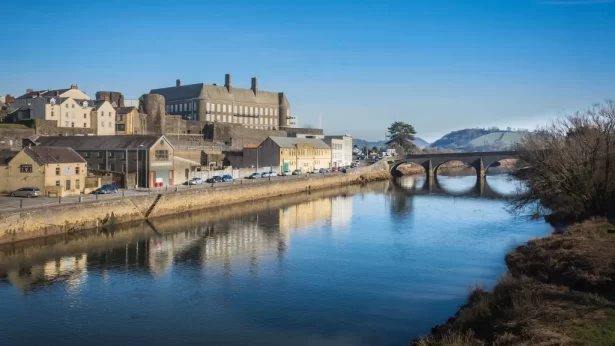 bridge-river-by-buildings-against-clear-sky